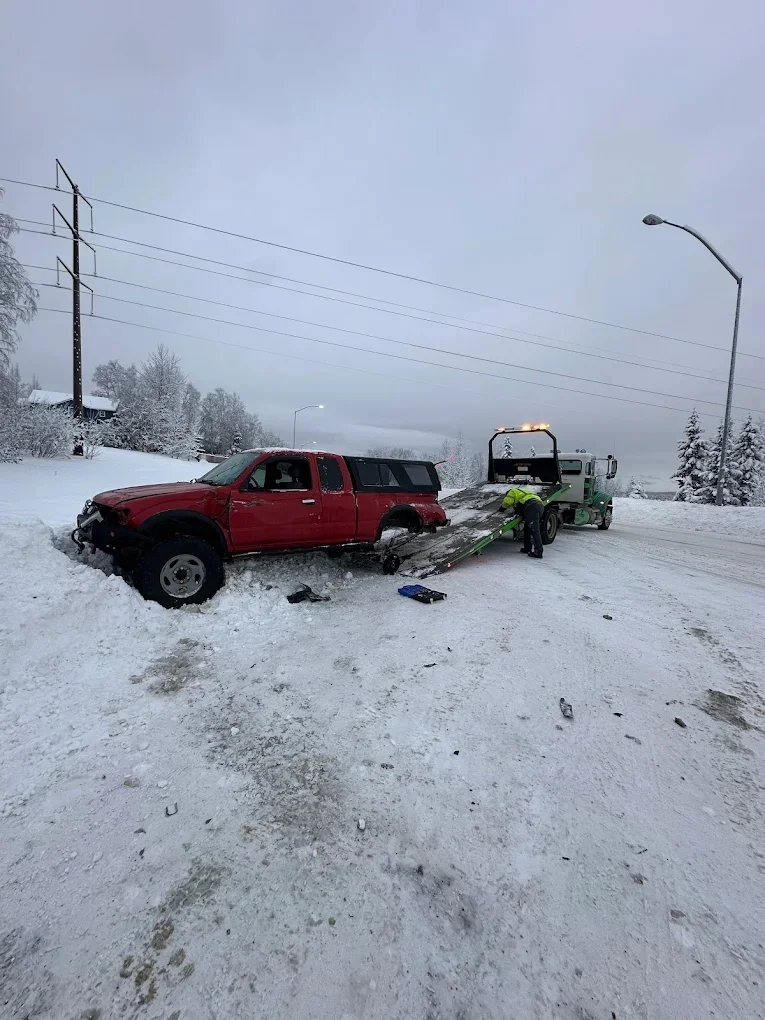 Elite Towing Peterbilt truck winching a vehicle out of a snowy ditch (Real Photo)