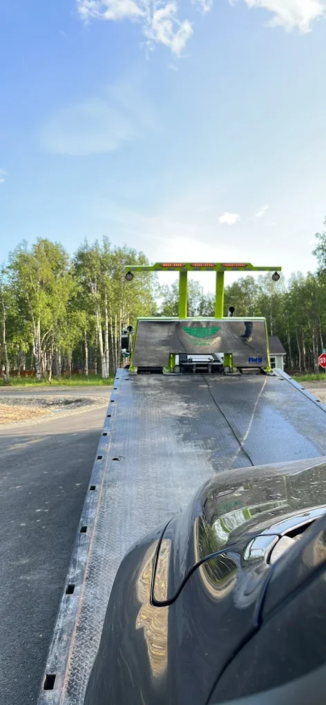 Looking down the steel flatbed deck of Elite Towing truck
