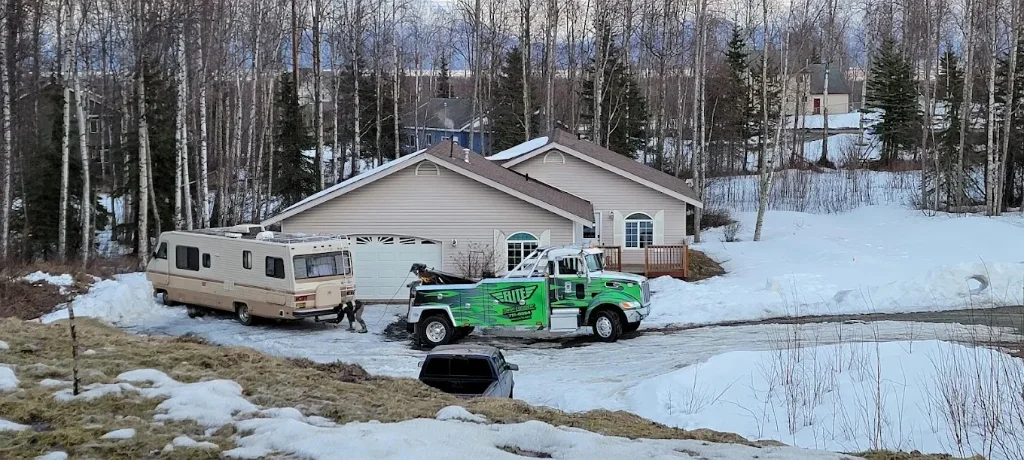 Real Elite Towing Peterbilt winching a large RV in a driveway